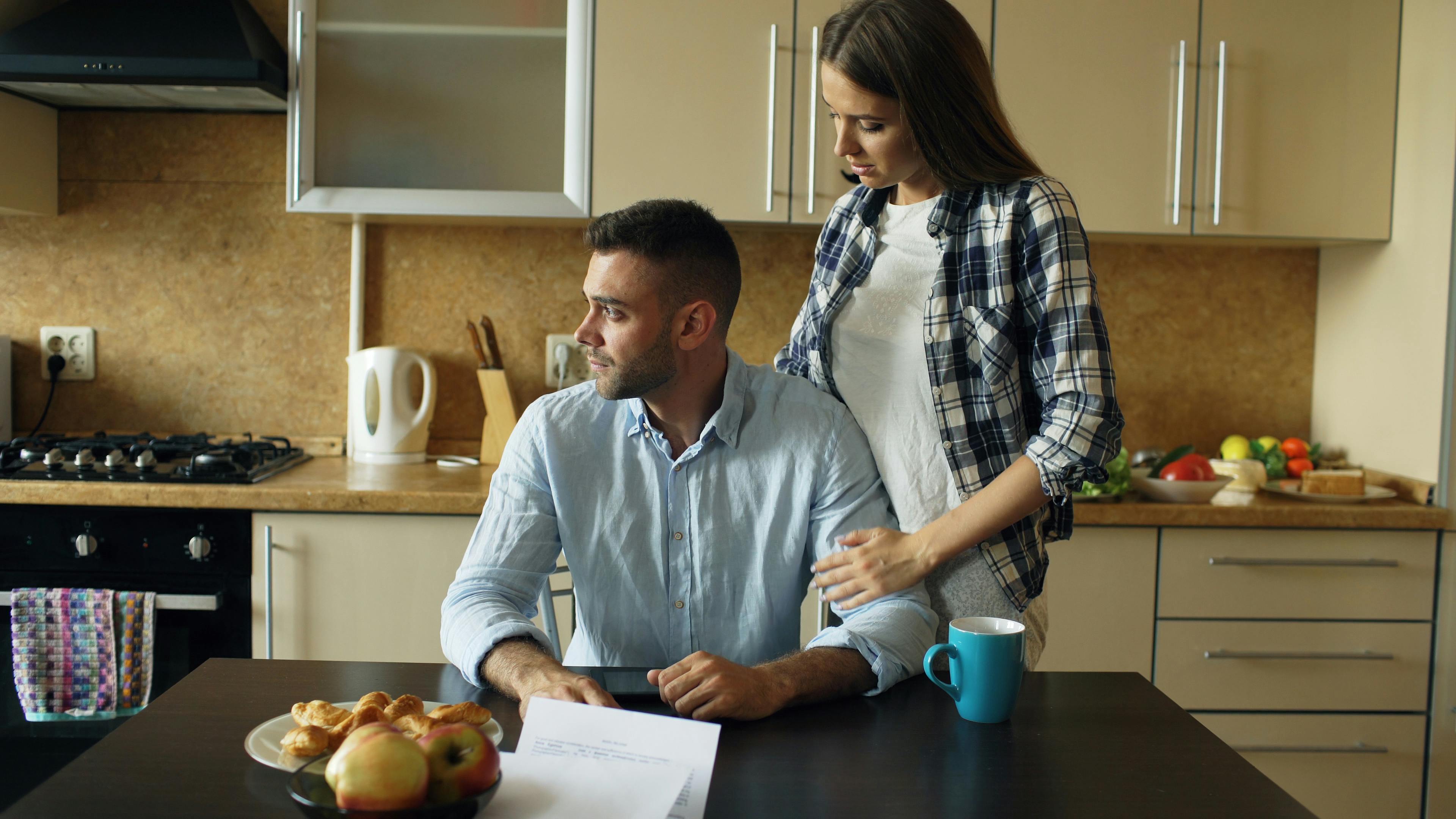 Concerned couple discussing an important decision together at home.